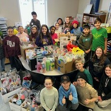 Students surrounded by gift packages smiling