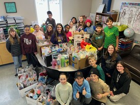 Students surrounded by gift packages smiling